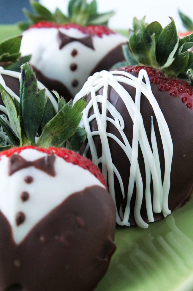 Chocolate covered strawberries on a green plate.