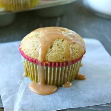 Peach muffin on a dark table with cinnamon glaze on top.
