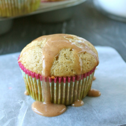 A peach muffin with light brown glaze on top.