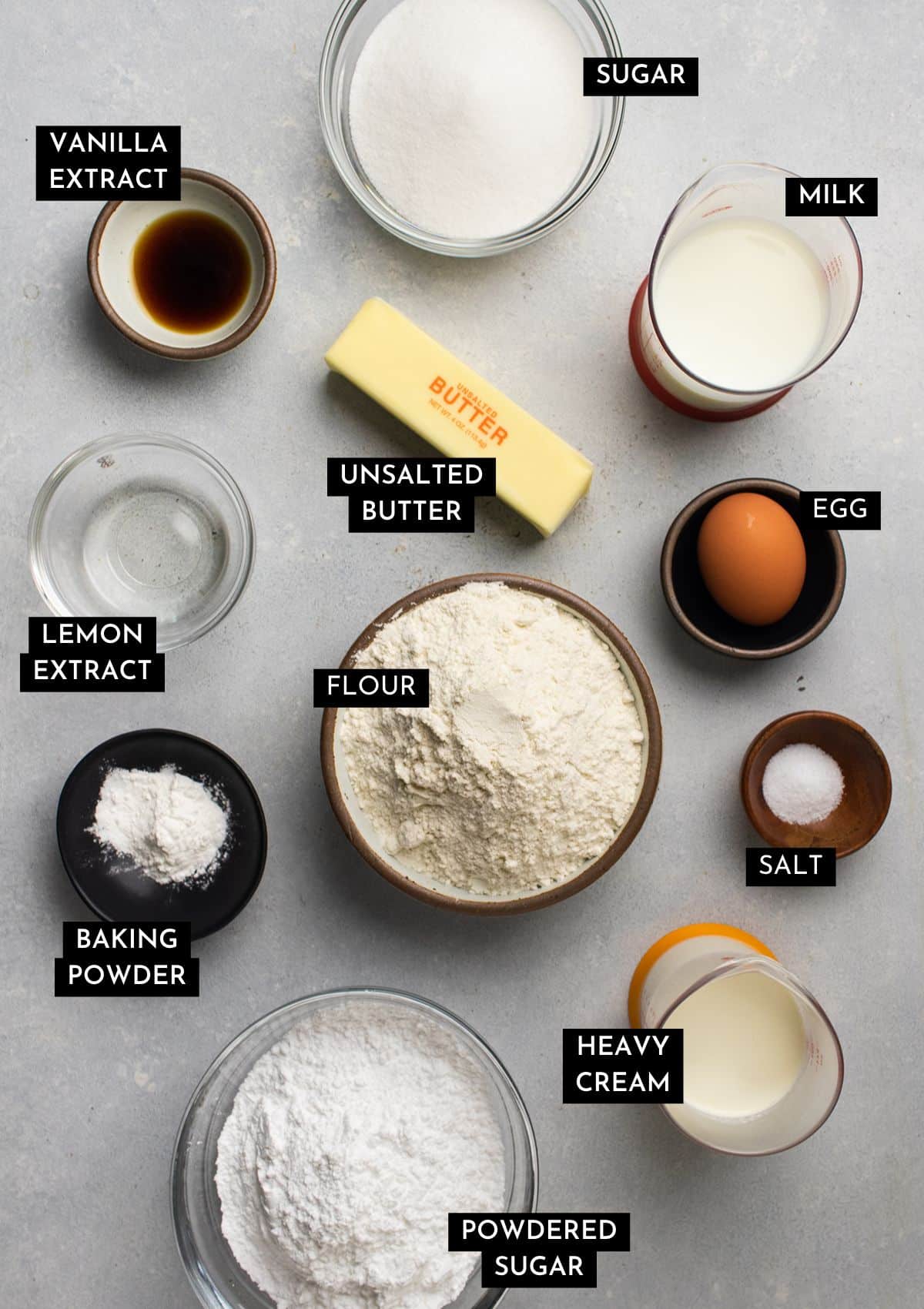 Cupcake ingredients, organized into individual bowls on a white table.