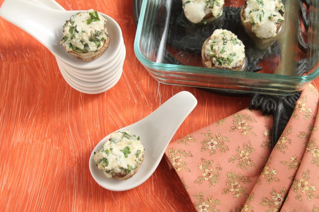 Cheese and herb stuffed mushrooms arranged on various serving dishes.