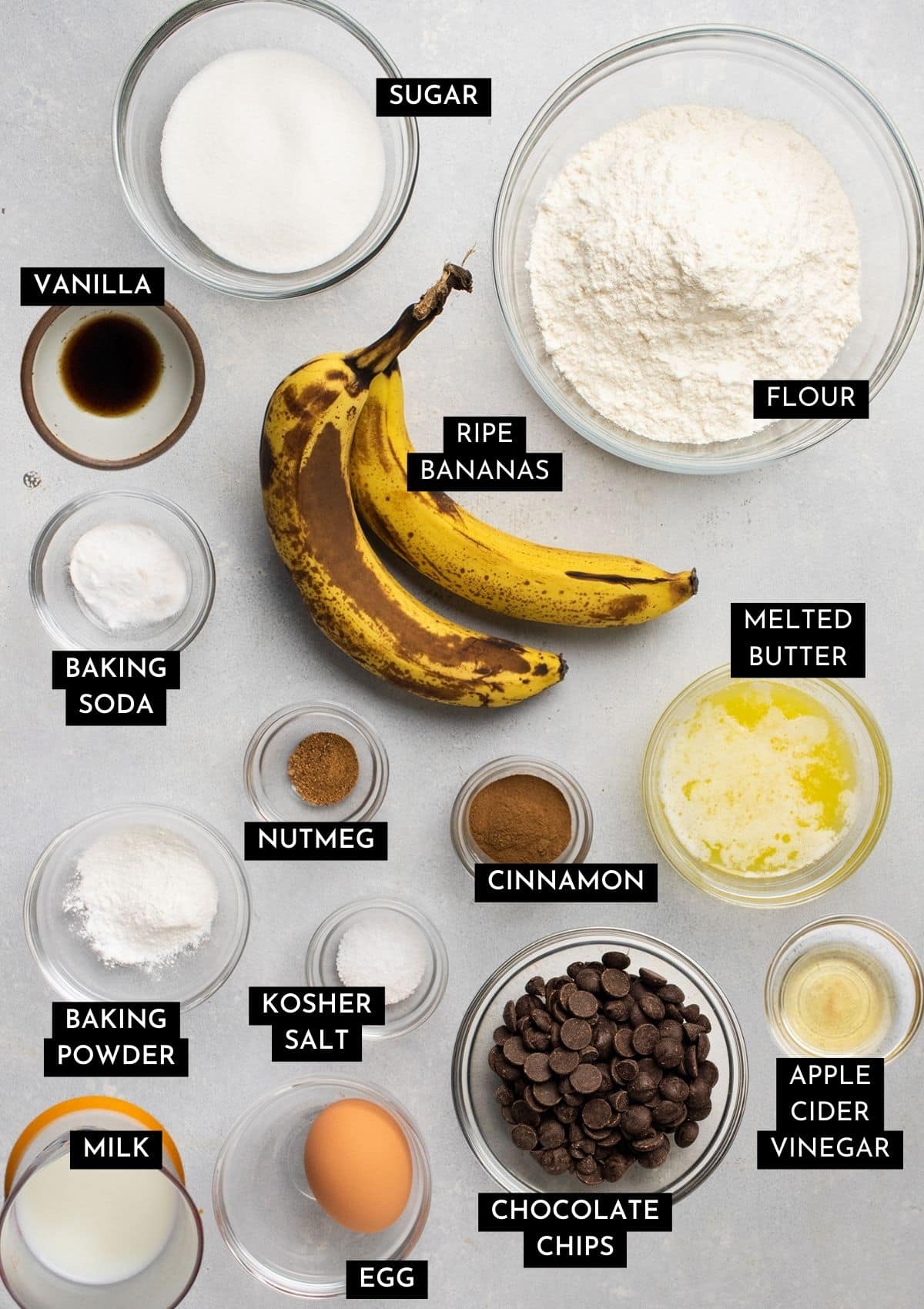 Banana muffin ingredients, organized into individual bowls on a white table.