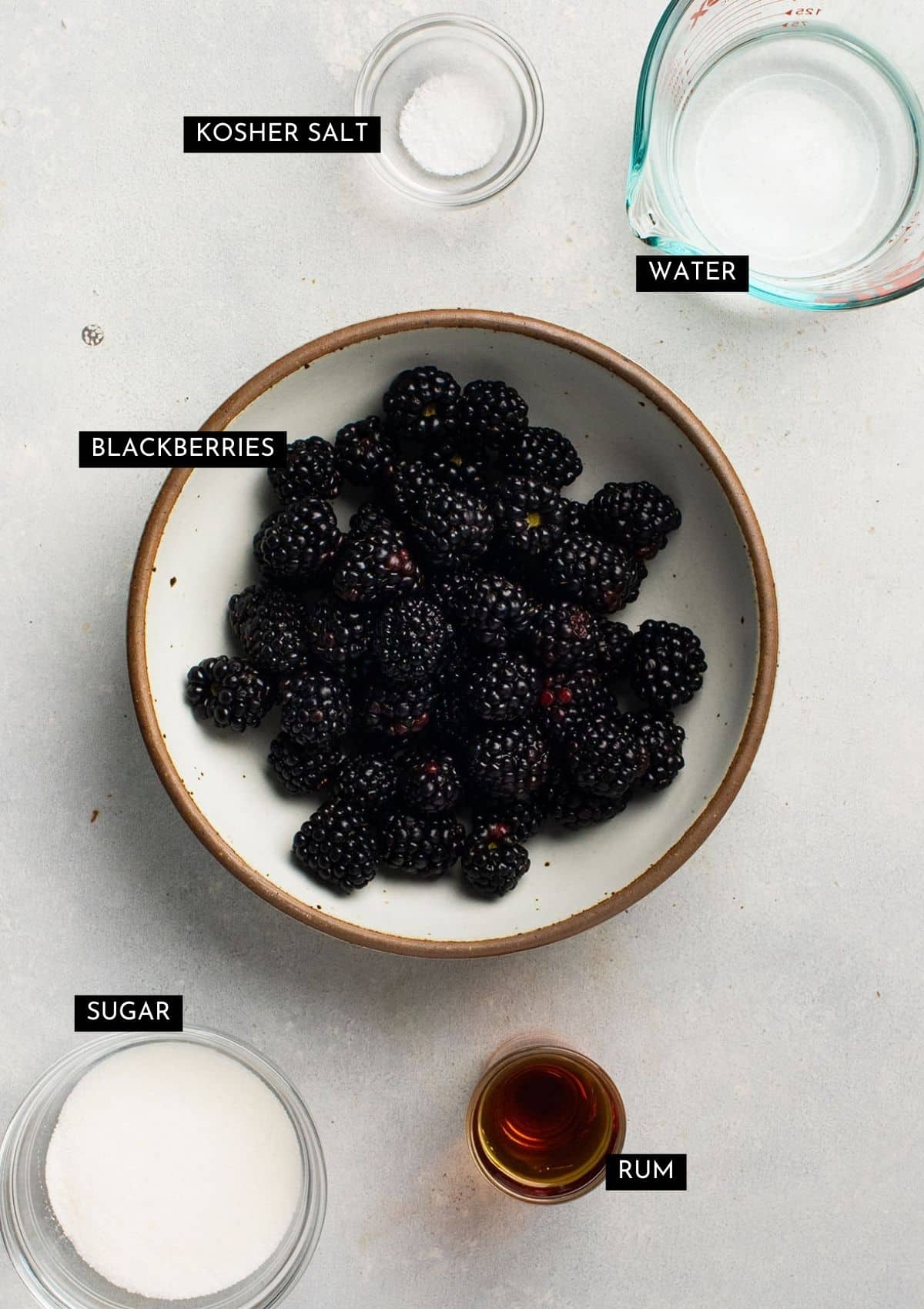 Fresh blackberries and other ingredients, organized into individual bowls.