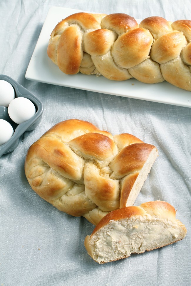 Several loaves of challah bread on a light background.
