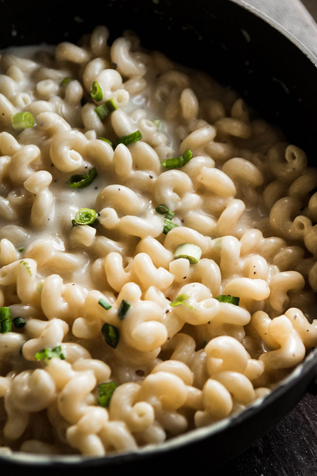 Dark pot filled with cavatappi pasta in a beer cheese sauce.