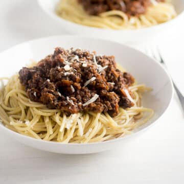 Italian sausage bolognese in a white bowl.