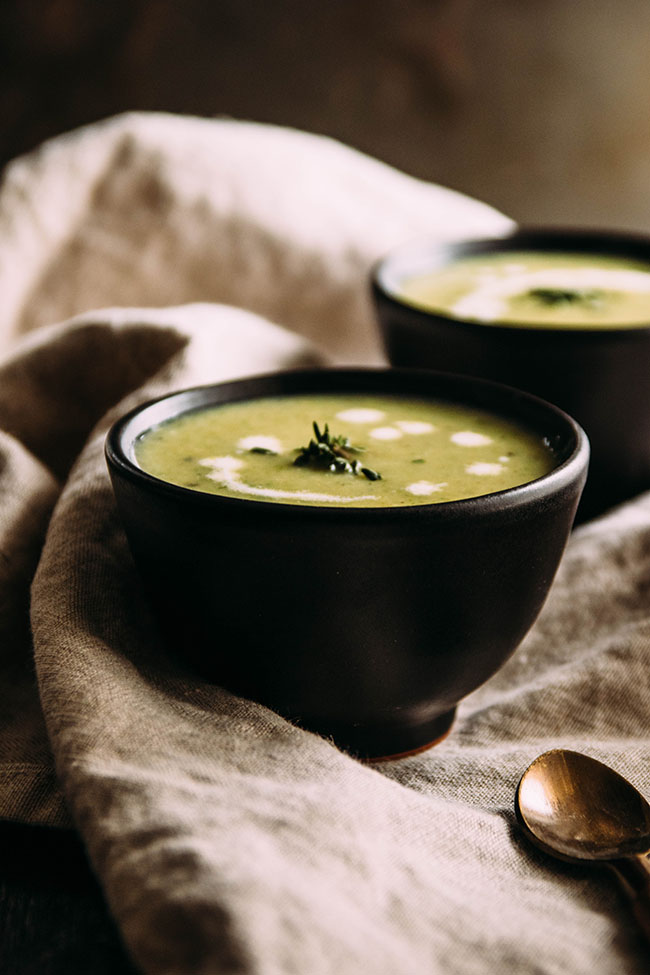 Light green soup in a small black bowl.