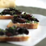 Crostini topped with cheese spread and roasted mushrooms.