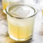 Whiskey lemonade in a short glass with a large square ice cube.