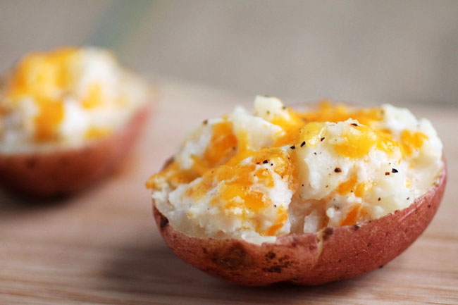 Close up of a twice baked potato topped with cheese and greek yogurt.