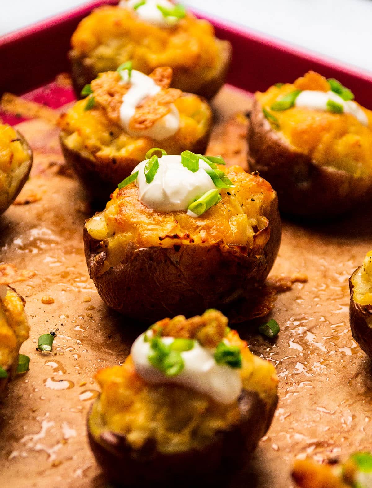 Twice baked potatoes on a baking sheet lined with parchment paper.