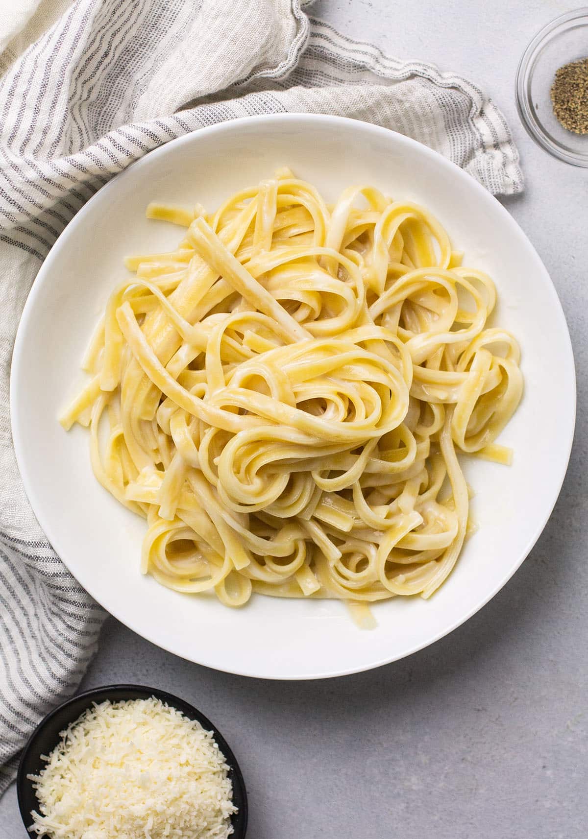 Fettuccine with white sauce in a shallow white bowl.