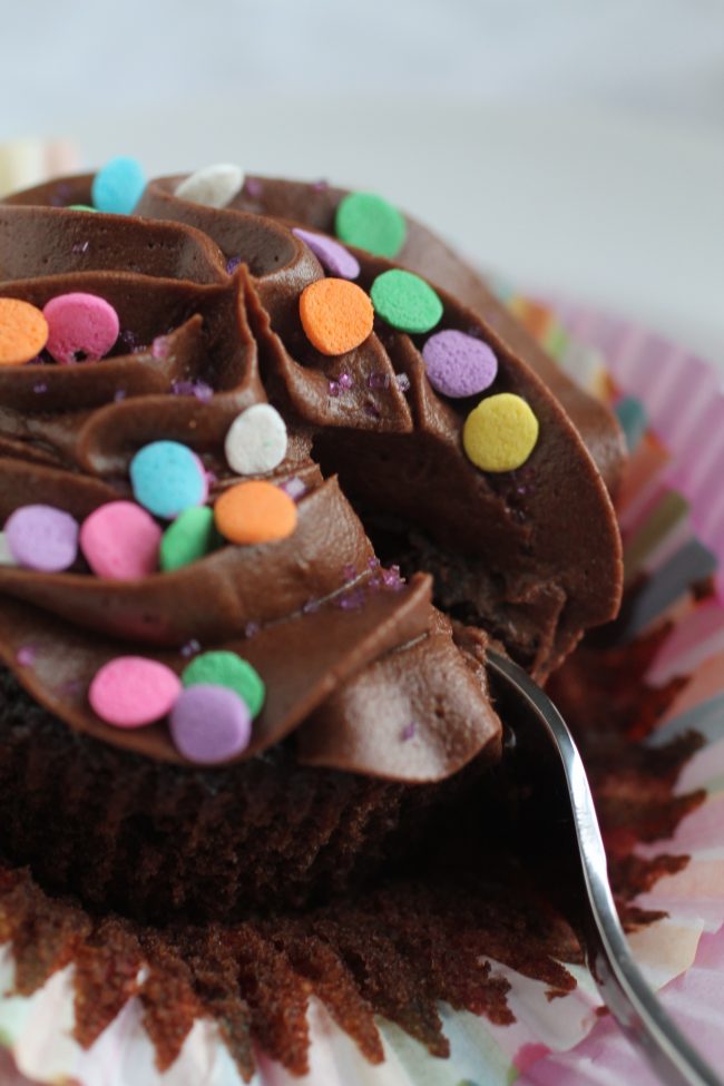 Silver fork cutting into a chocolate cupcake.