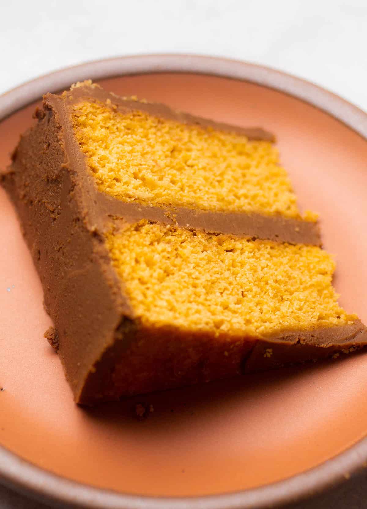 A slice of butterscotch cake on a small peach colored plate.