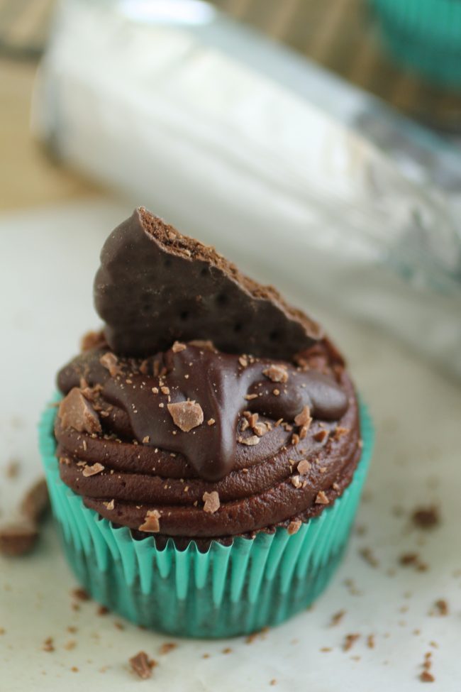 Chocolate cupcake topped with frosting and a cookie.