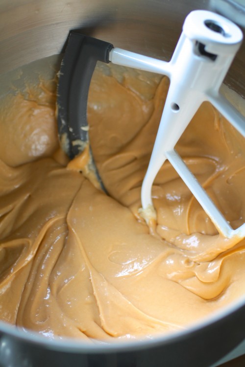 White paddle mixing butterscotch cake batter in the bowl of a stand mixer.