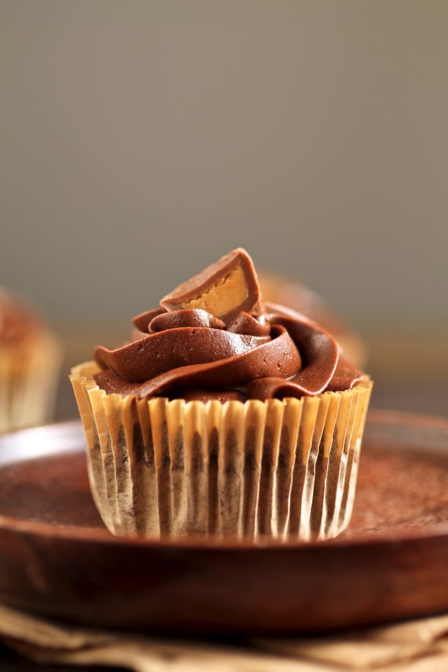 Chocolate cupcake topped with half a peanut butter cup.