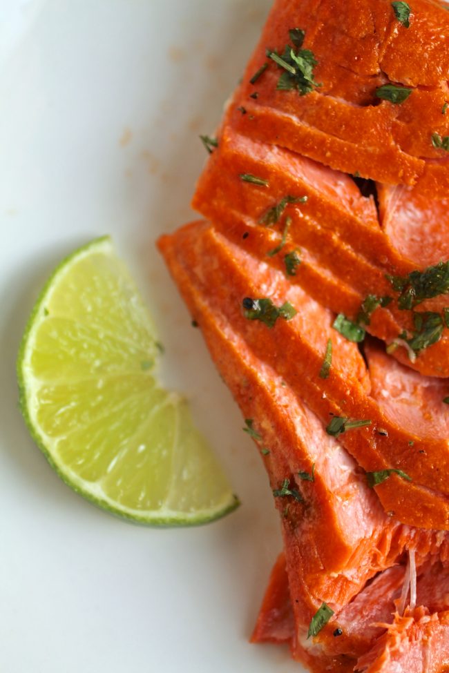 Flaked salmon next to a lime wedge.