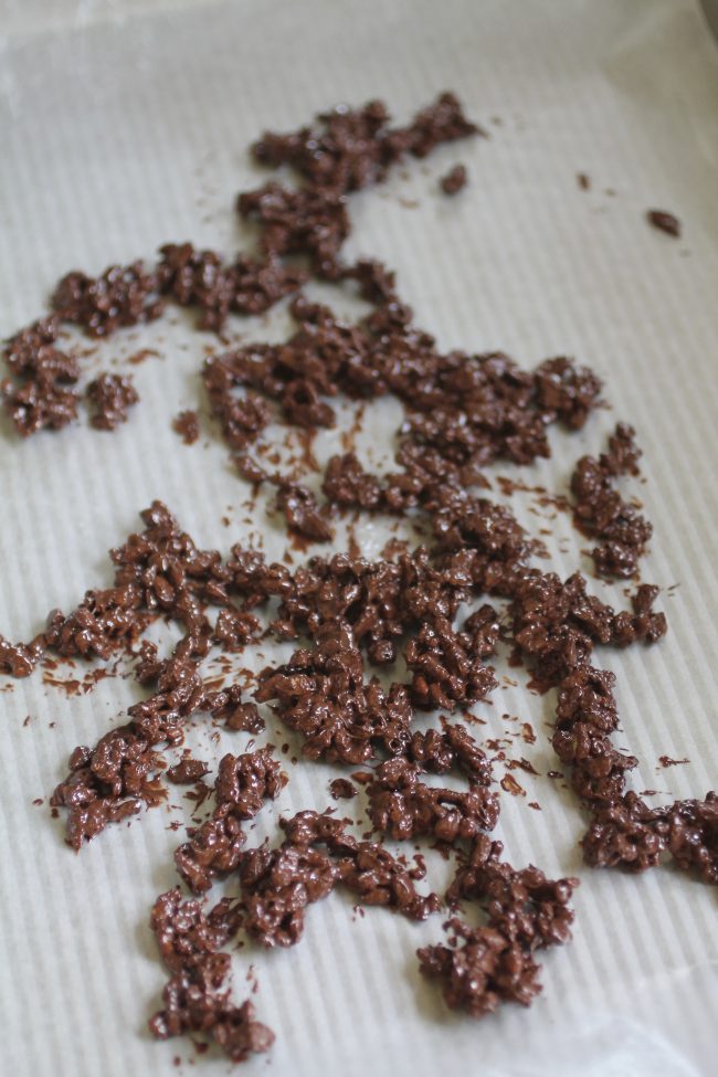 Chocolate and puffed rice cereal drying on a piece of waxed paper.