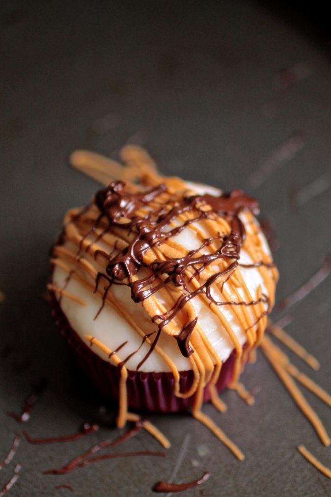 Cupcake drizzled with melted chocolate and melted peanut butter.