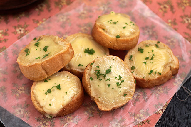 A pile of crostini sitting on a pink napkin.