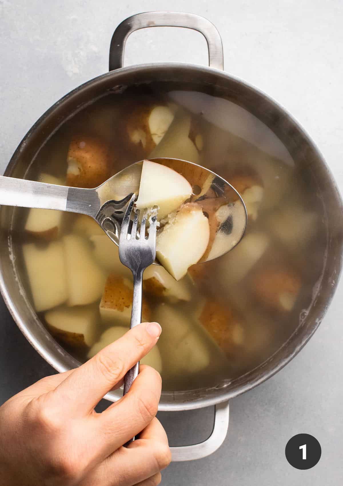 Piercing a cooked potato with a fork to check for doneness.