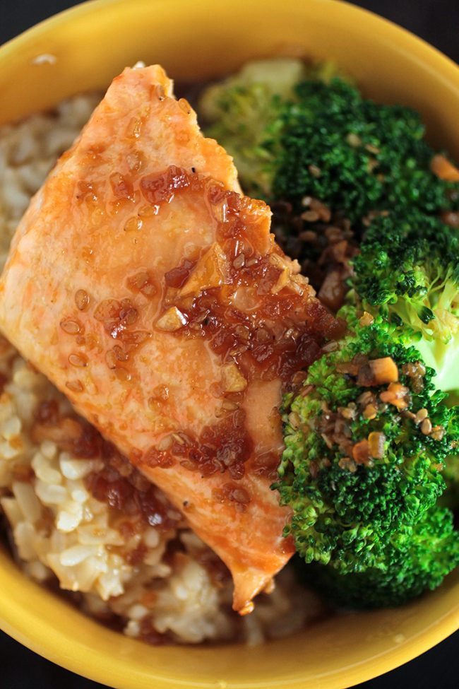 Close up of a piece of salmon next to steamed broccoli.