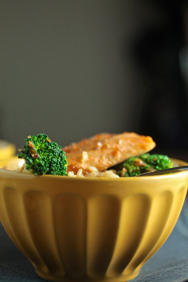 Yellow bowl with broccoli and salmon inside.