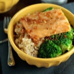Yellow bowl filled with rice, broccoli, and roasted salmon.