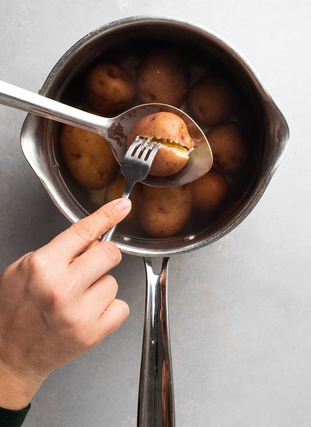 Piercing a potato with a fork to check for doneness.