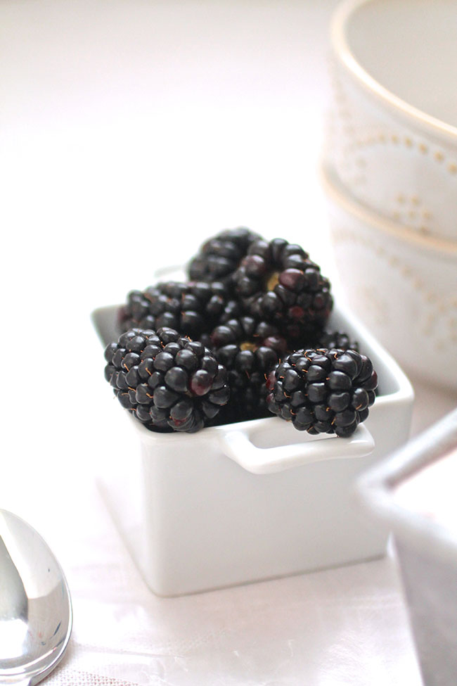 Fresh blackberries in a small white dish.