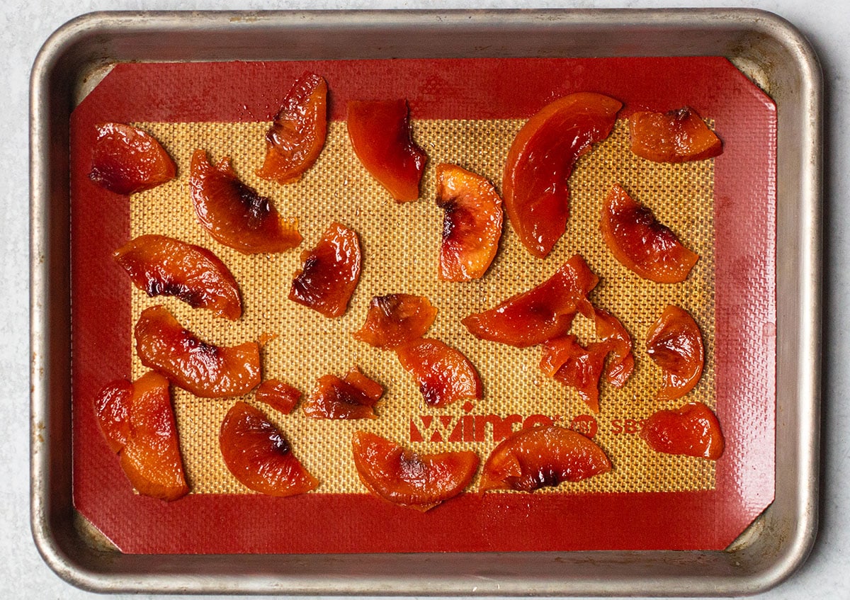 Cooked peaches on a baking sheet lined with a silpat.