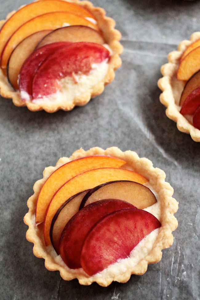 Three small tartlets on a piece of parchment paper.