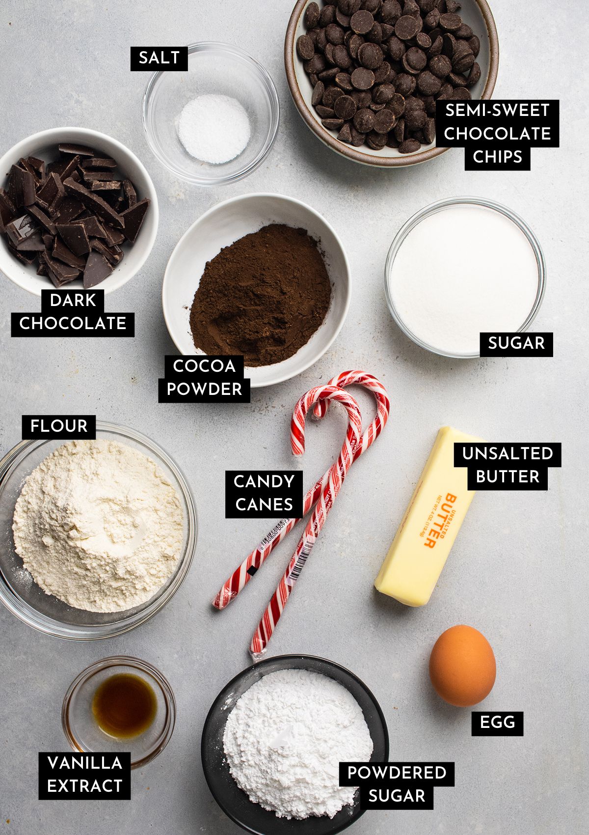 Cookie ingredients organized into individual bowls on a white table.