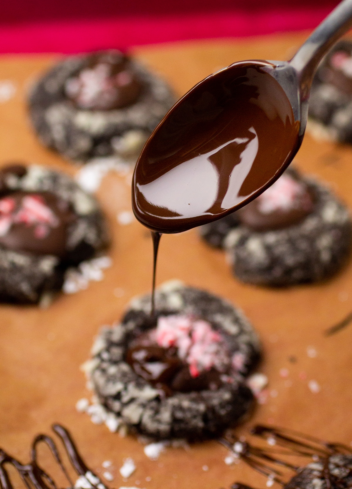 Spoon drizzling melted chocolate over cookies.