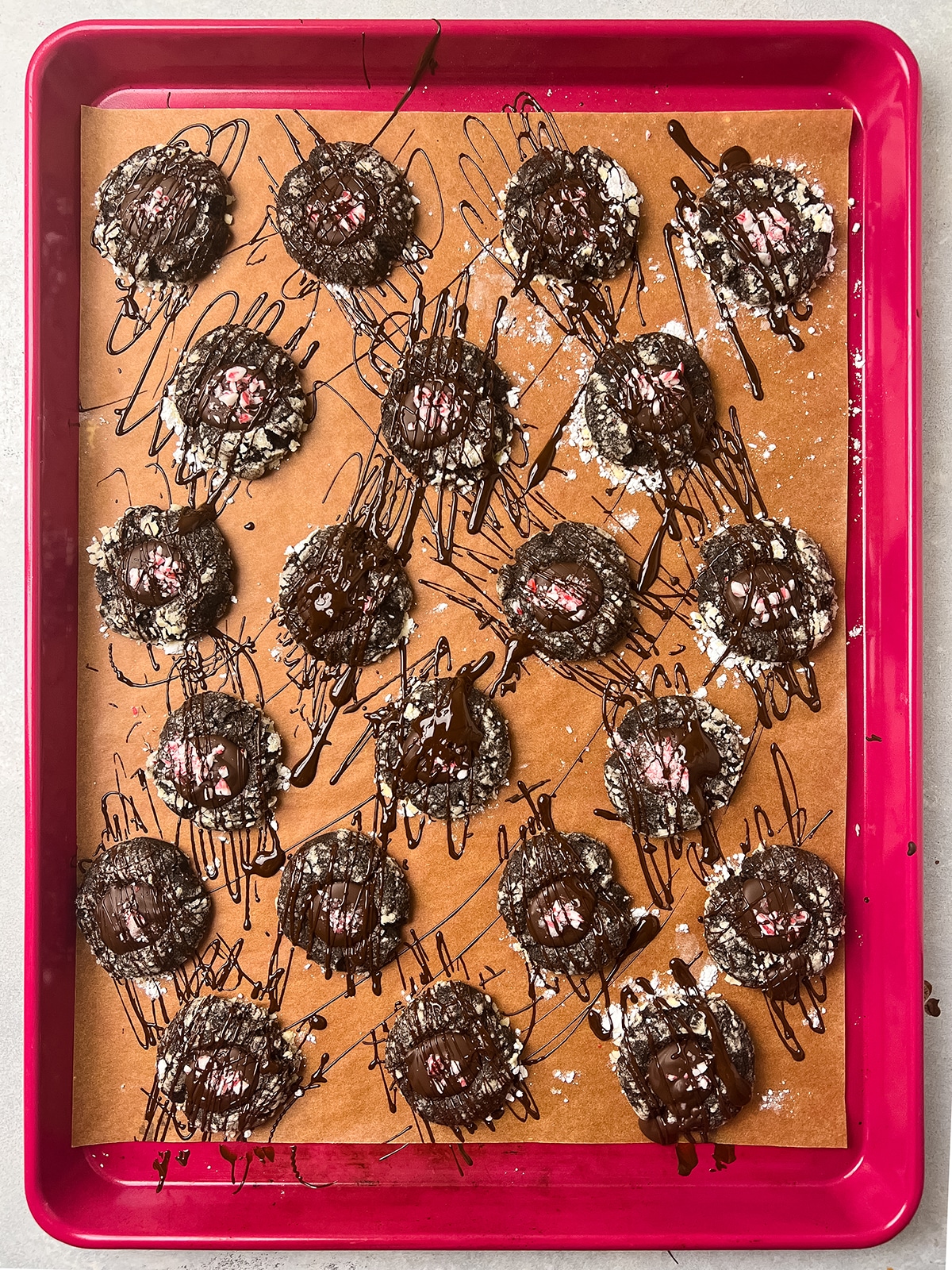 Thumbprint cookies on a pink sheet pan lined with parchment paper.
