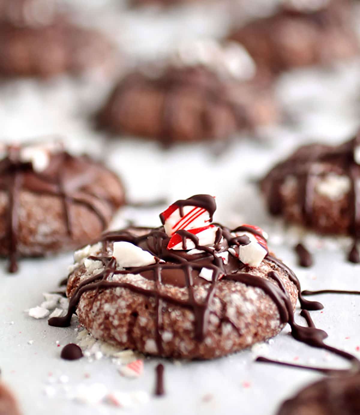 Peppermint thumbprint cookies on a baking sheet lined with parchment.