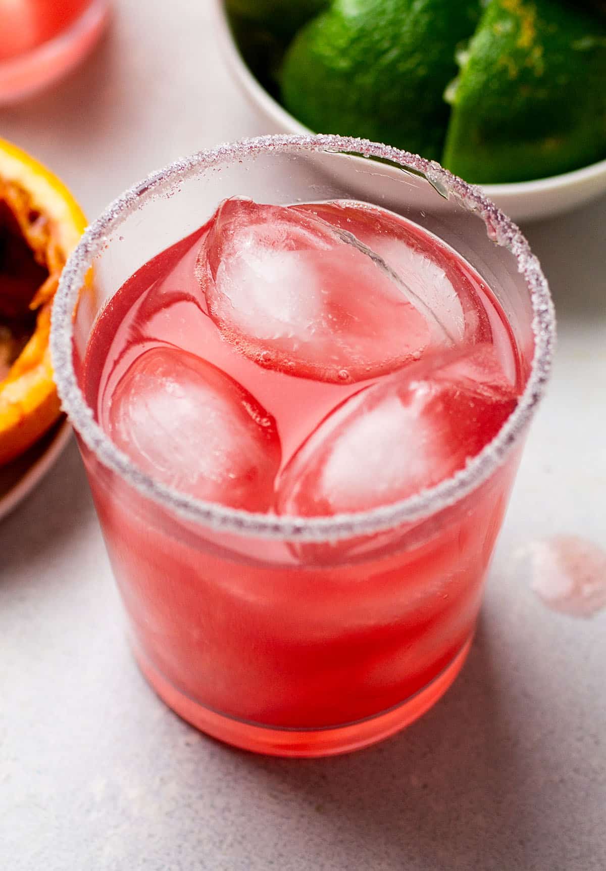 Blood orange cocktail in a short glass with sugar on the rim.