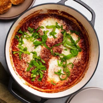 Italian baked eggs with fresh basil in a large dutch oven.