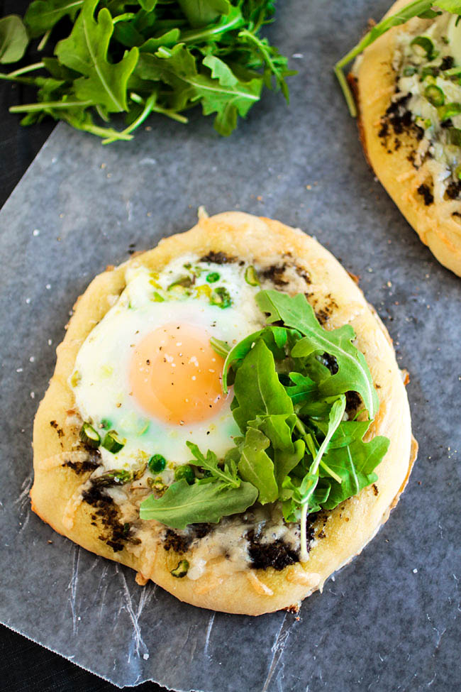 Breakfast pizza topped with fresh arugula.