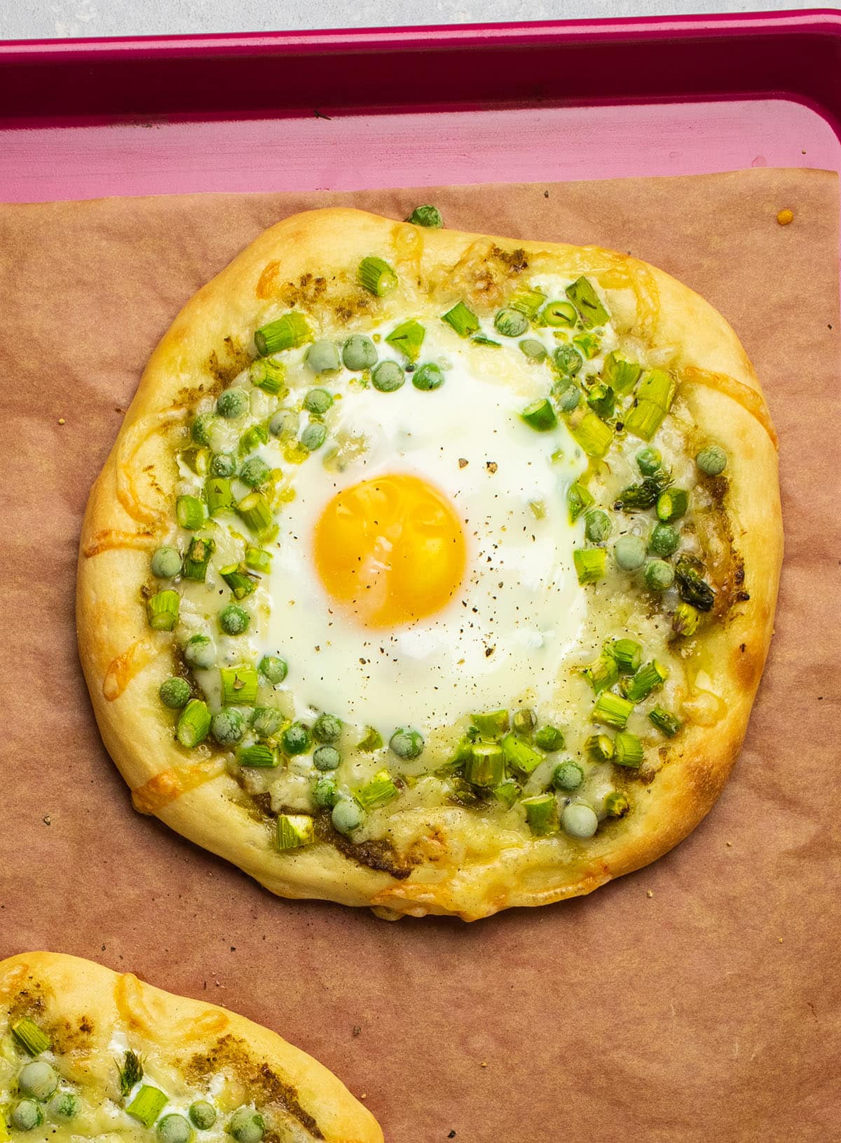 Pizza with peas, asparagus, and a baked egg.
