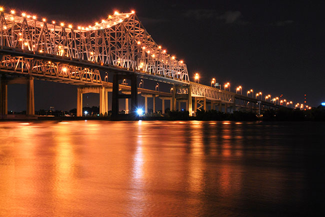 A New Orleans bridge, lit up at night.