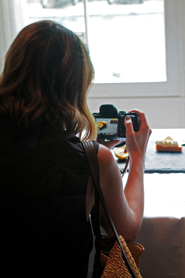 Woman taking a photo of a piece of cake.