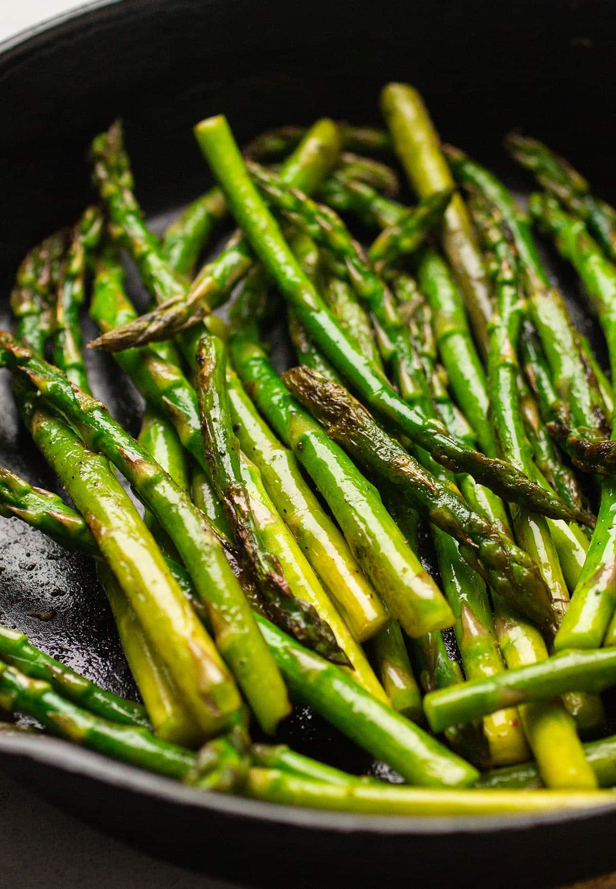 Cooked asparagus in a cast iron skillet.
