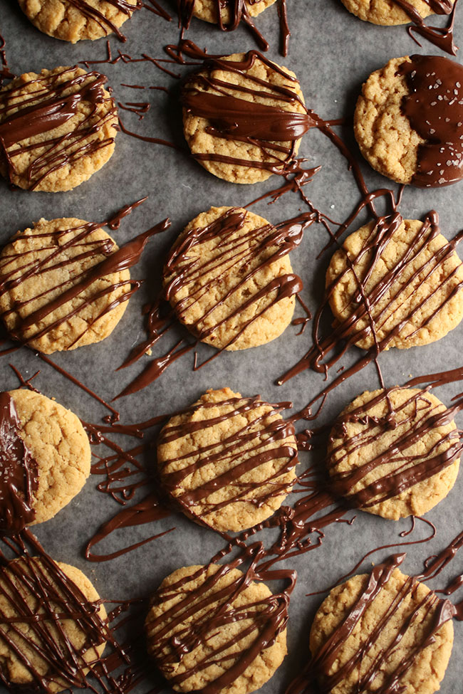 Overhead view of a tray of peanut butter cookies drizzled with melted chocolate.