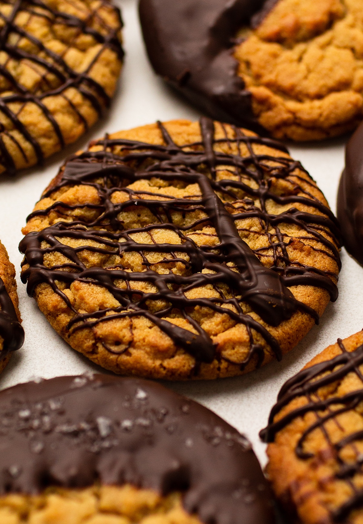 Peanut butter cookies with chocolate decorations, sitting on a white plate.
