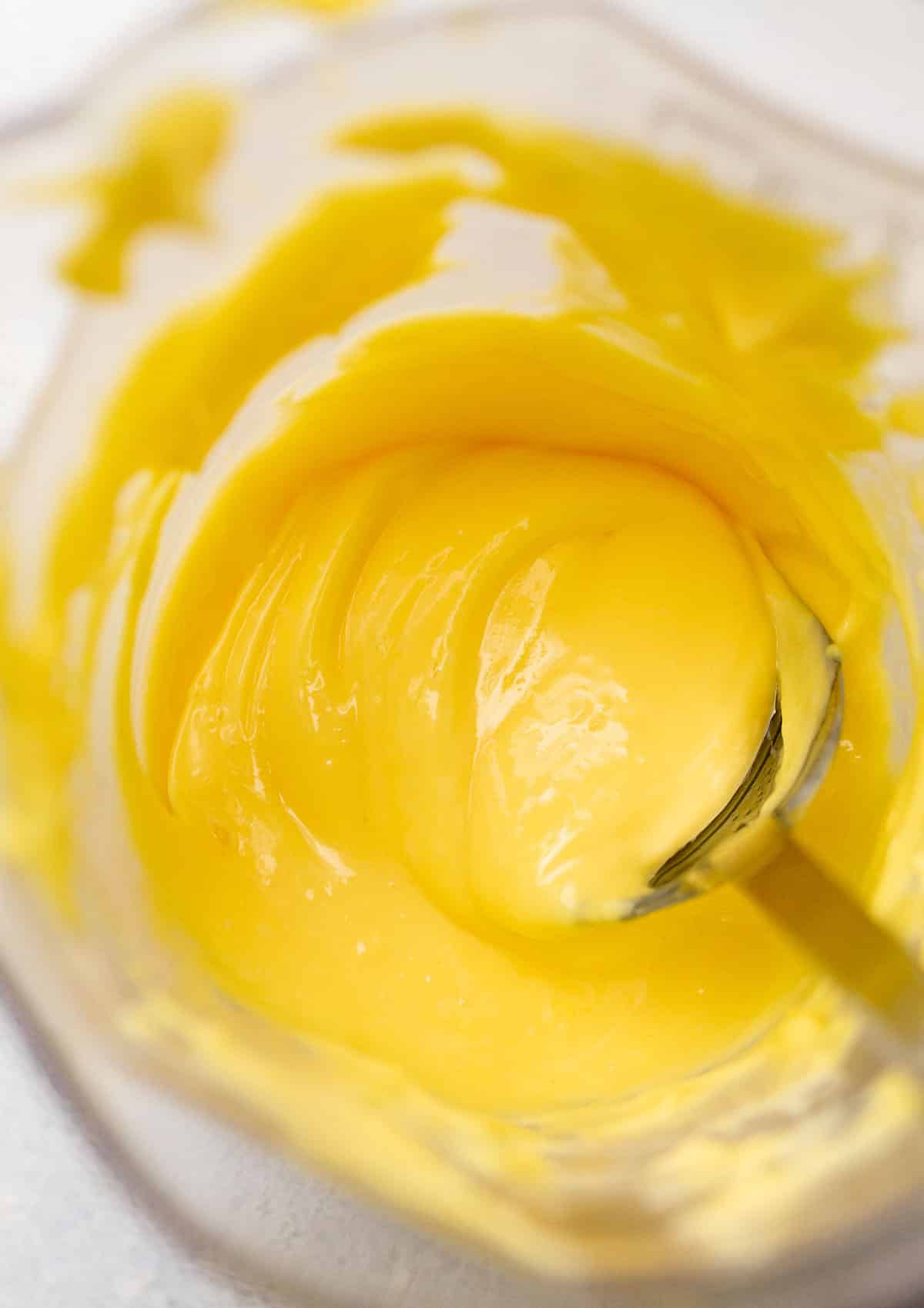 Stirring hollandaise with a silver spoon. 