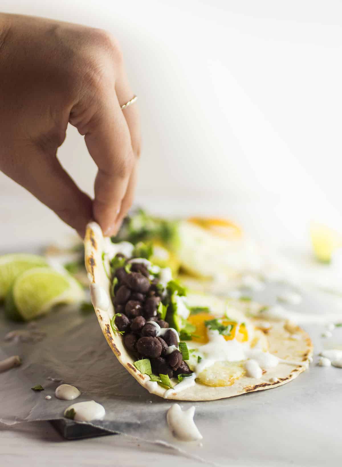 Hand folding a breakfast taco into shape.