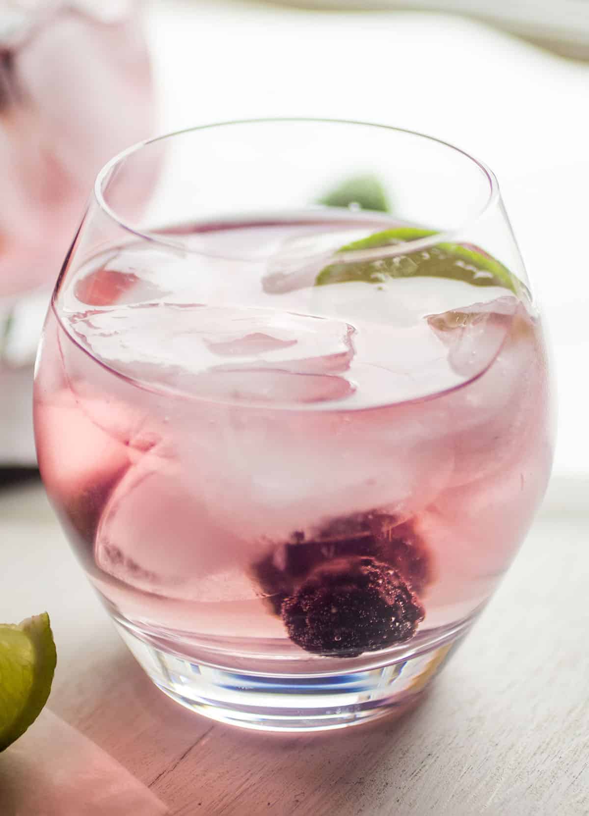Blackberry vodka tonic garnished with fresh blackberries and a lime wedge.