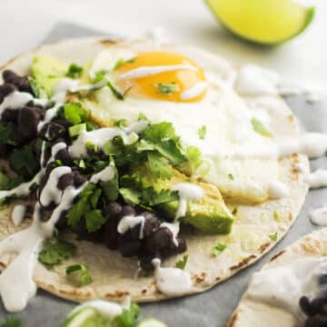 Tortilla filled with fried egg, avocados, and black beans.
